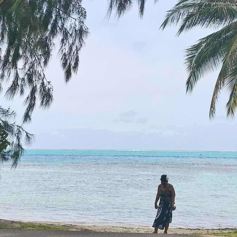 Moorea peaceful scene with local walking the beach.