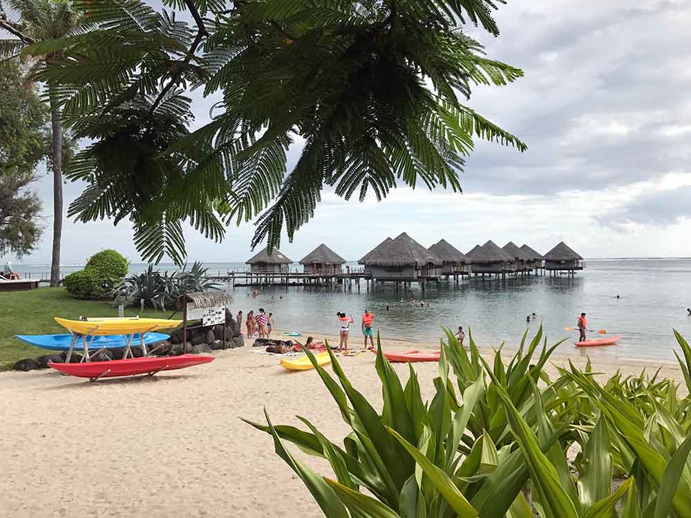 A daytime view of the overwater bungalows and beach at Le Meridien Tahiti.