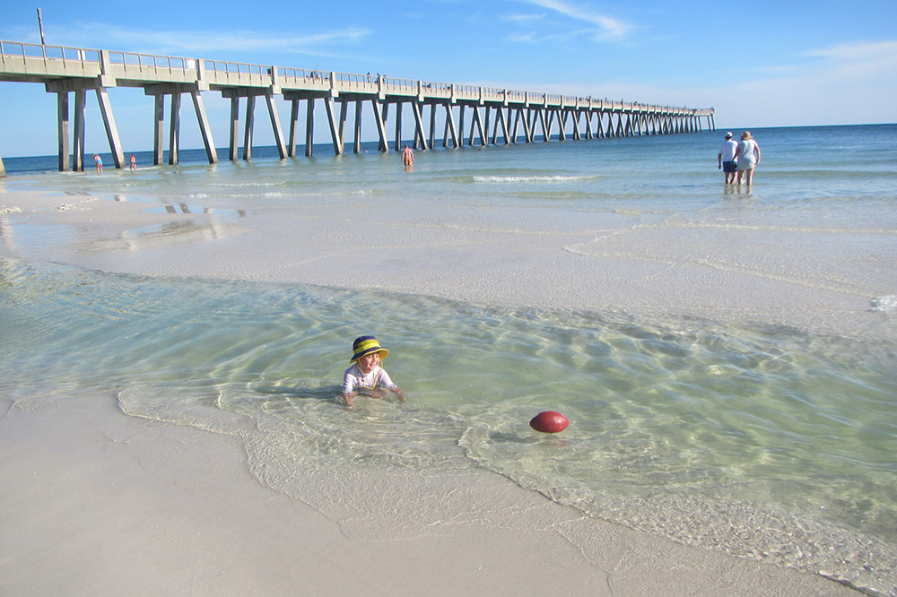 Navarre Beach and Pier showing child playing in tide pool