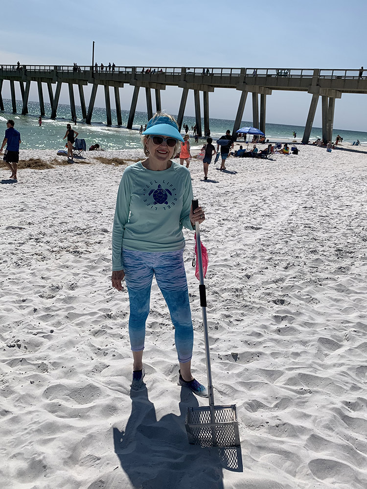 Debbra Brouillette with shelling rake on Navarre Beach by the Pier.