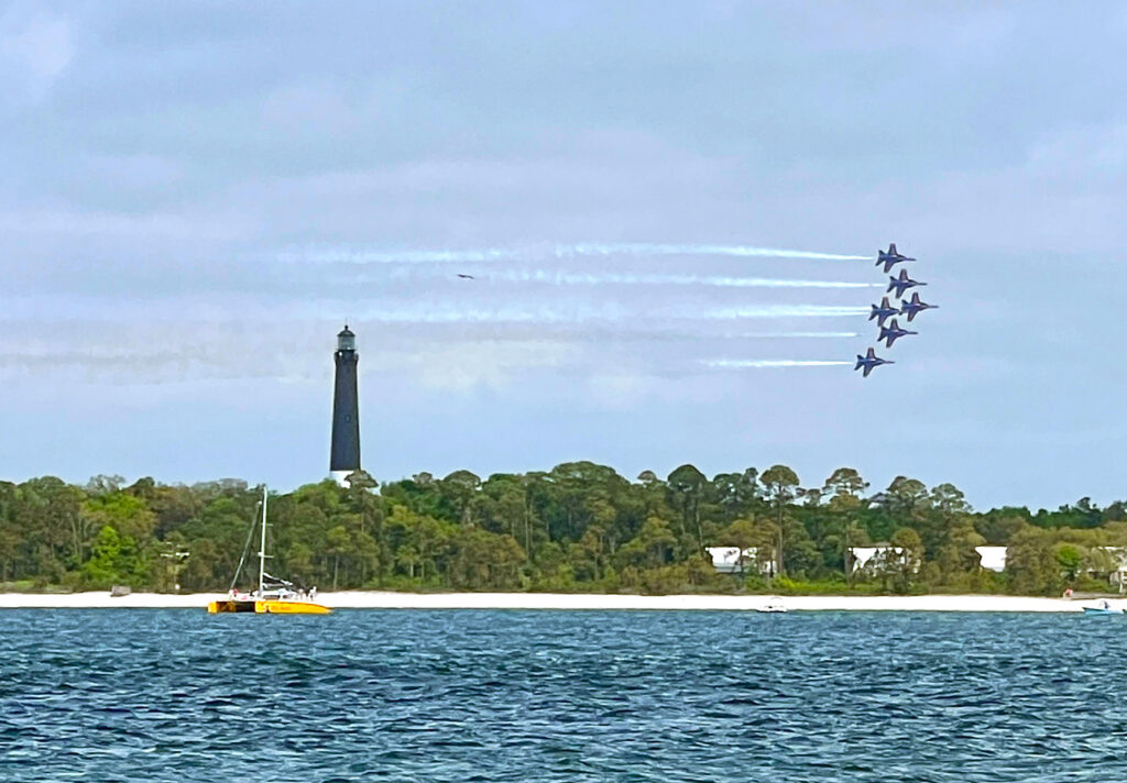 Watching the Blue Angels practice from Fort Pickens beach. The Pensacola Lighthouse can be seen across the Bay. ©Debbra Dunning Brouillette